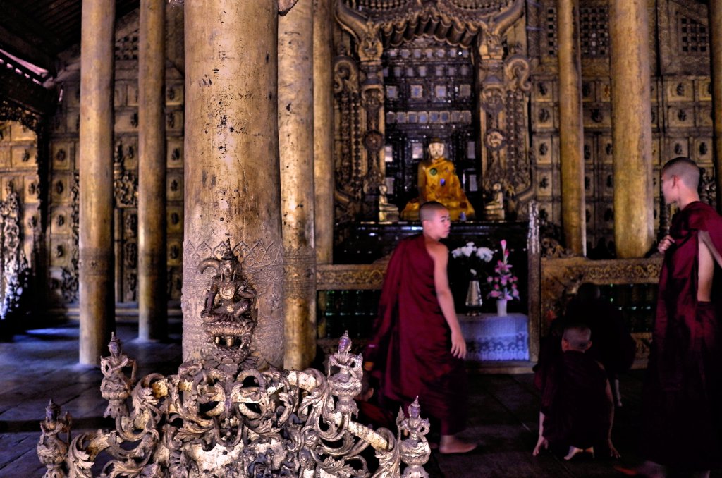 Monks at interior of temple in Myanmar, providing an offering