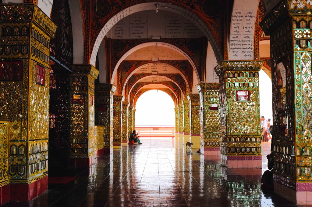 Interior of Sutaungpyai Pagoda in Mandalay, Myanmar. Beautiful arches with mirrored tiled columns.