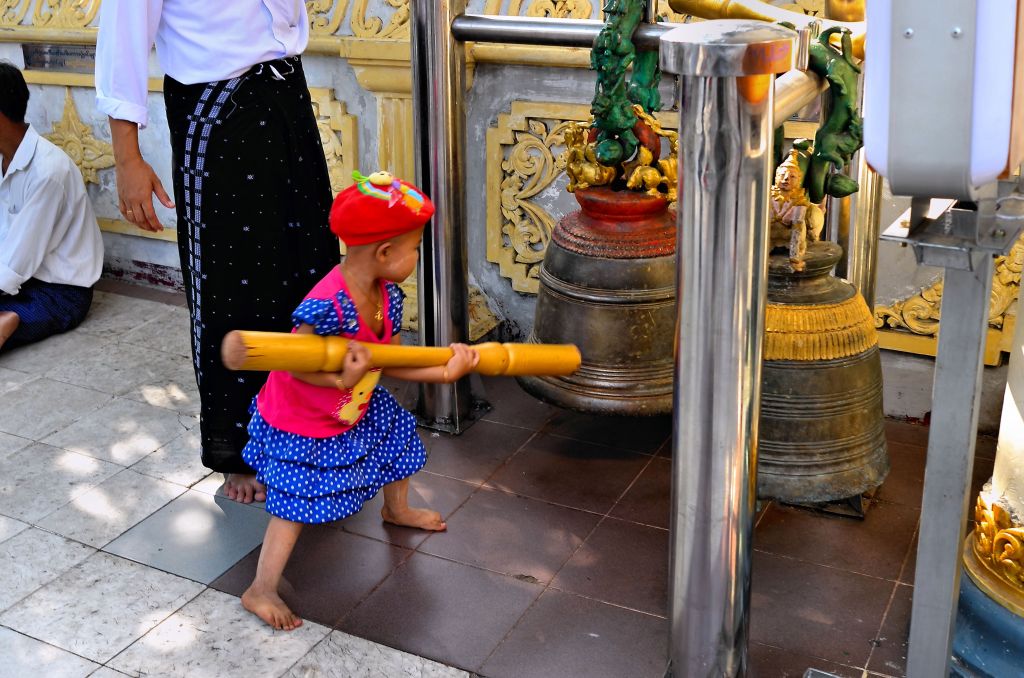 Child ringing a bell at the Shwedagon Pagoda in Yangon, Myanmar