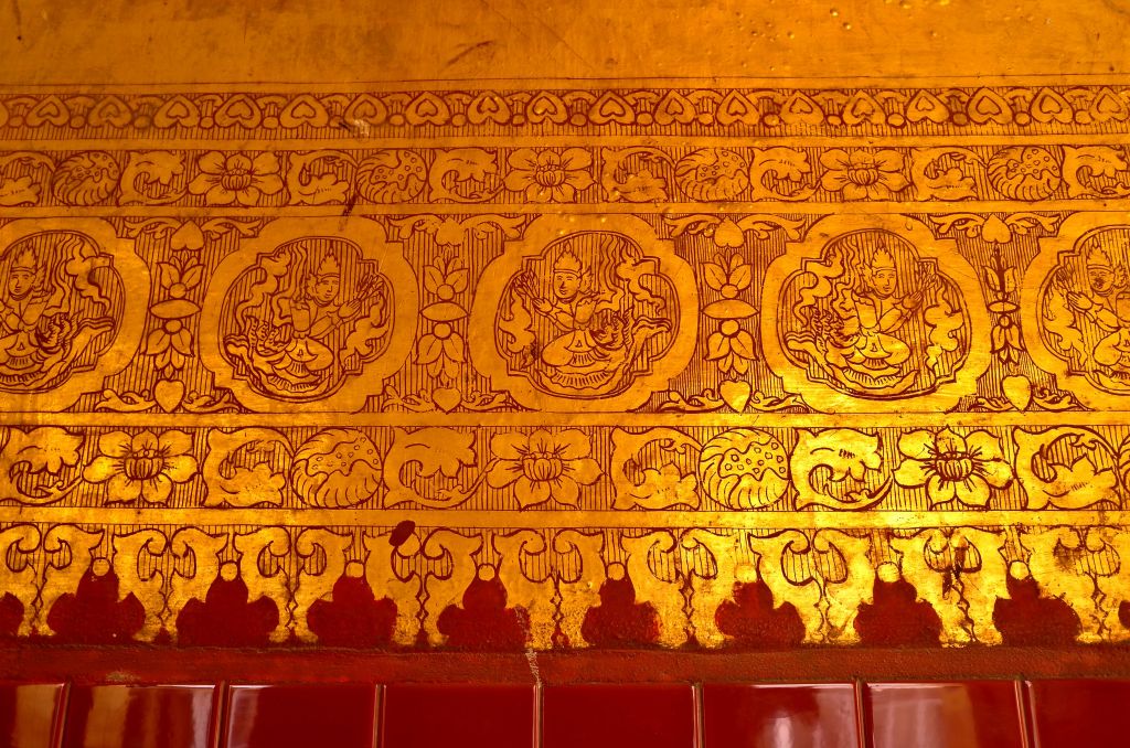 Detailed gold and red paintings on the ceilings and walls of the Sutaungpyai Pagoda in Mandalay, Myanmar